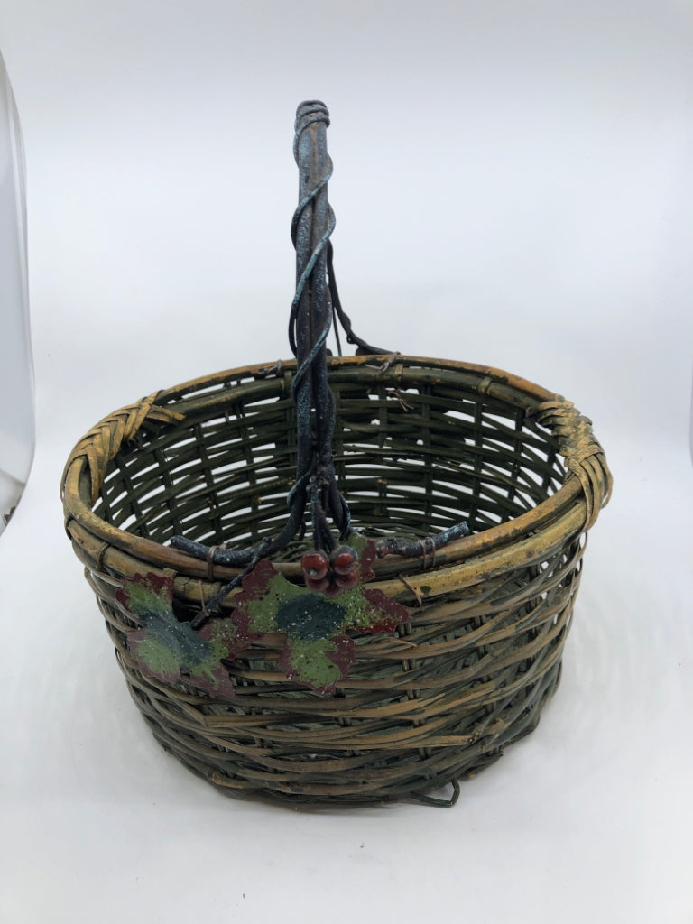 GREEN WOVEN BASKET W METAL HANDLE AND LEAVES.