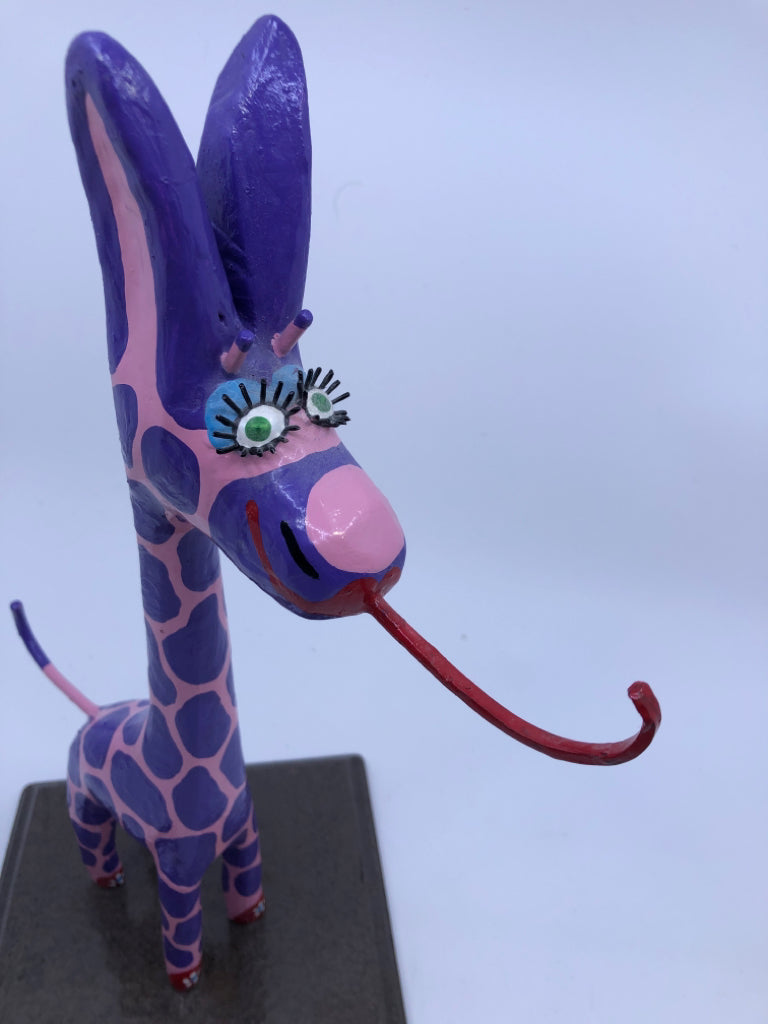 PINK AND PURPLE GIRAFFE ON WOOD STAND.