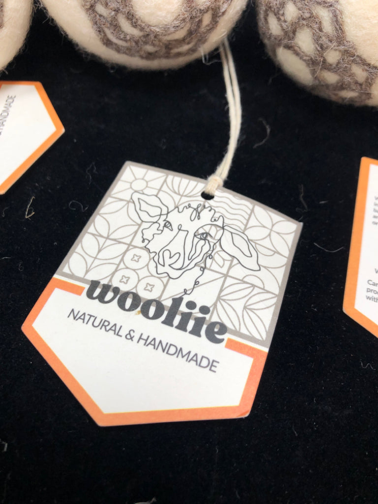 4 EMBROIDERED WOOLIIE WOOL DRYER BALLS IN BAG.