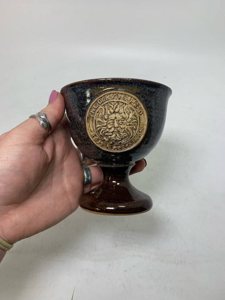 SHORT FOOTED POTTERY GOBLET W/ THE GORGONS HEAD MEDALLION IN CENTER.