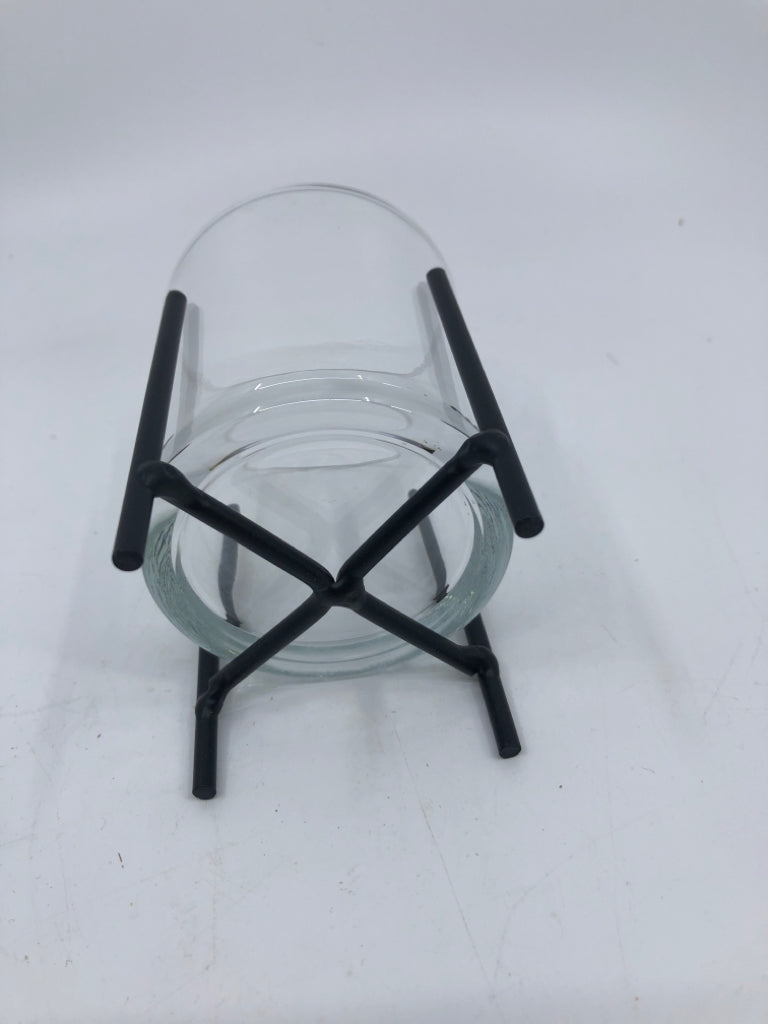 SMALL GLASS VOTIVE HOLDER IN BLACK METAL STAND.