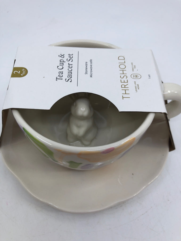 NIP TEACUP/SAUCER SET WHITE W/ PAINTED PURPLE FLOWERS RABBIT IN CENTER.