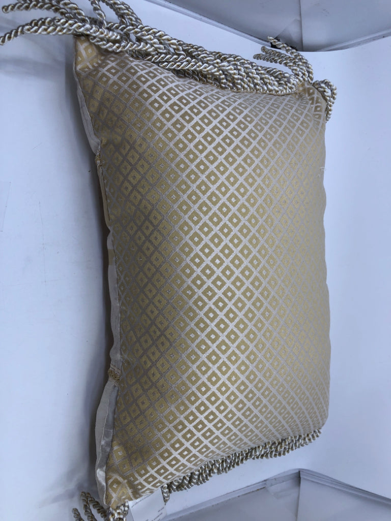 CREAM RECTANGLE AND GOLD PILLOW WITH TASSELS.