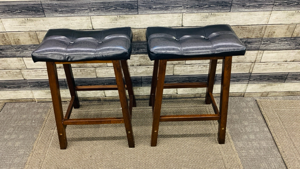 2 SADDLE SHAPED BAR STOOLS W FAUX LEATHER SEATS.