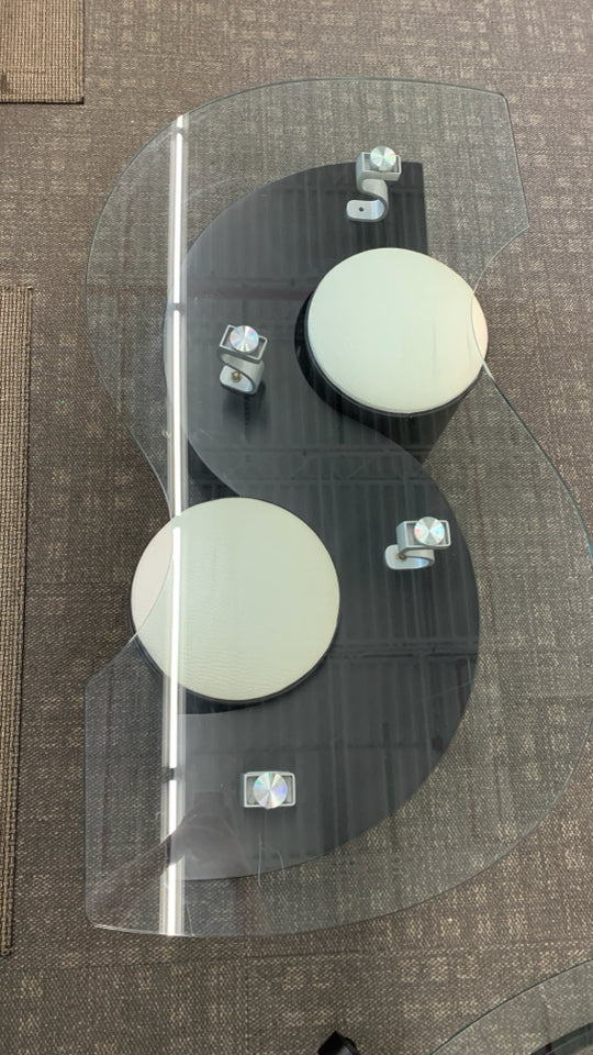 MODERN S-SHAPED GLASS TOP COFFEE TABLE W/ROLLING STORAGE SEATS.