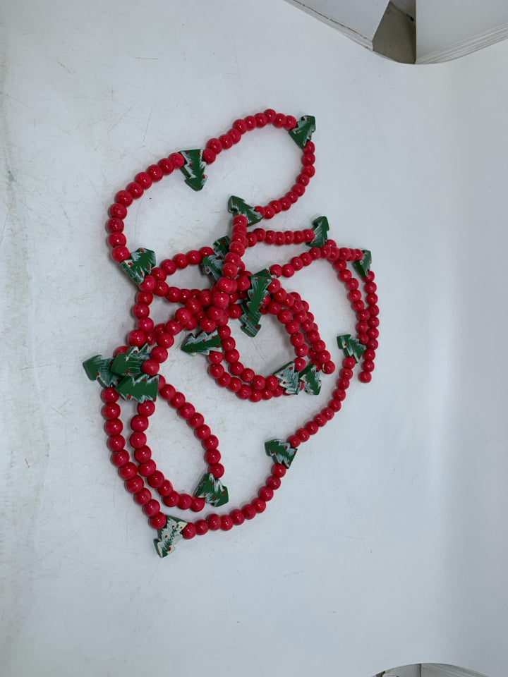 RED BEADED GARLAND W/ CHRISTMAS TREES.