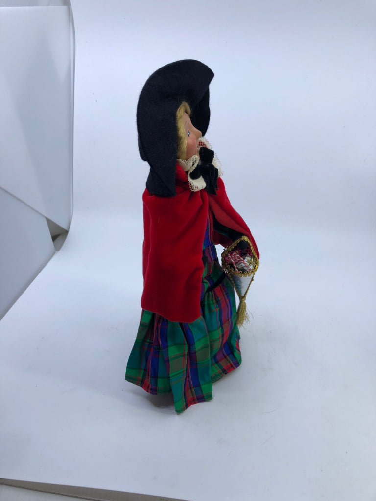 BYERS' CHOICE WOMAN IN RED COAT AND PLAID DRESS.