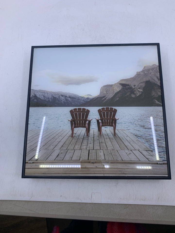 2 CHAIRS FACING WATER IN BLACK FRAME.