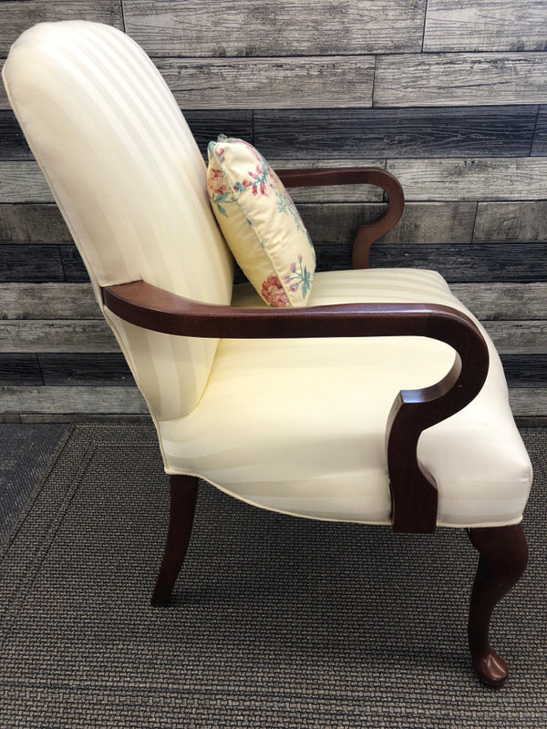 IVORY ARM CHAIR WITH FLOWER PATTERN PILLOW.