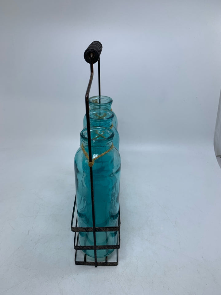 3 BLUE BOTTLES IN METAL CARRIER.