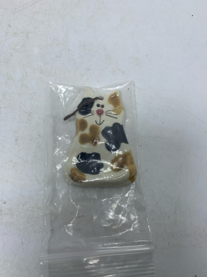 SMALL SPOTTED POTTERY CAT FIGURINE IN BAG.