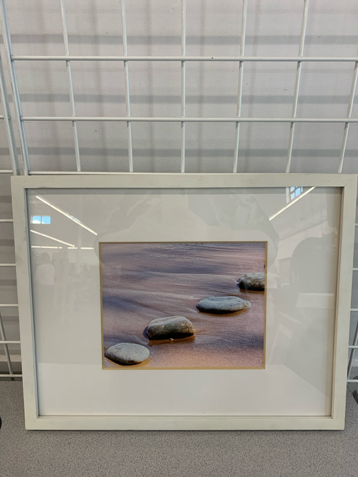 ROCKS ON BEACH PHOTO IN WHITE FRAME.