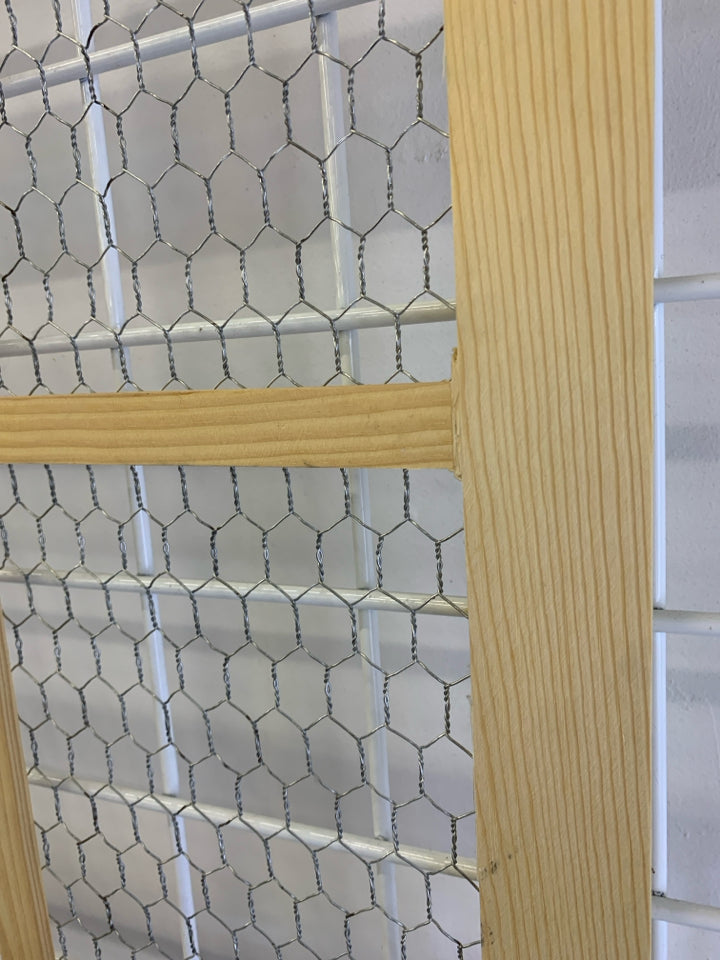 CHICKEN WIRE IN BLONDE WINDOW FRAME.