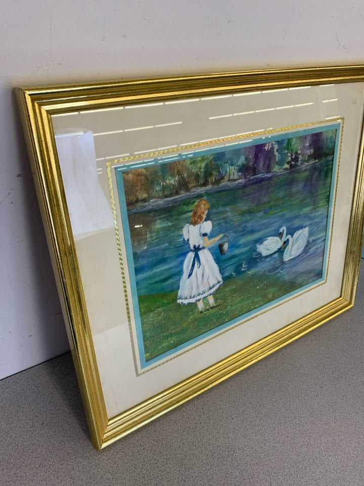 GIRL W/ BUCKET FEEDING SWANS WALL ART IN GOLD FRAME.