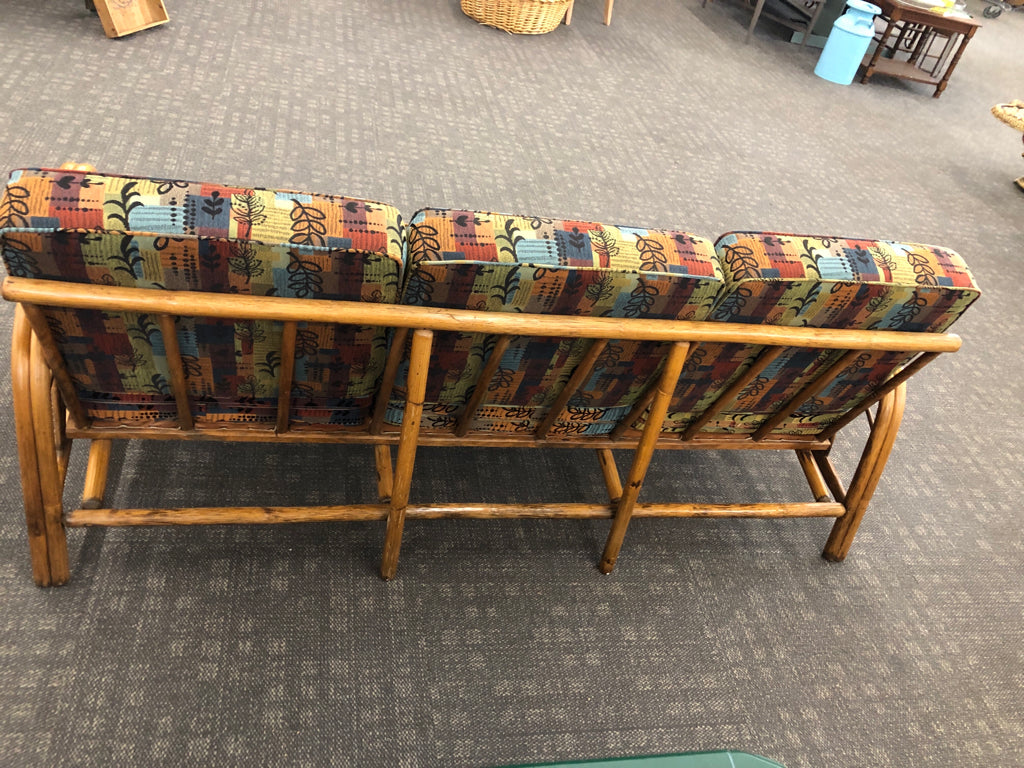 RATTAN SOFA W/PATTERNED FABRIC.