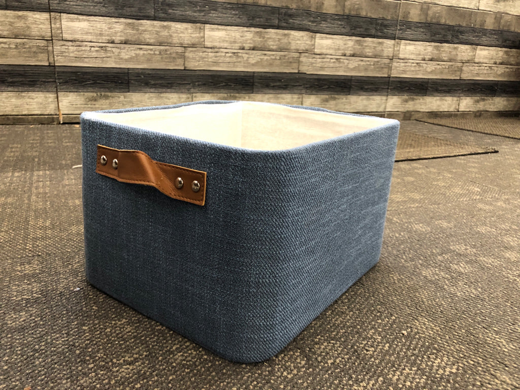 BLUE FABRIC STORAGE BIN W/LEATHER HANDLES.