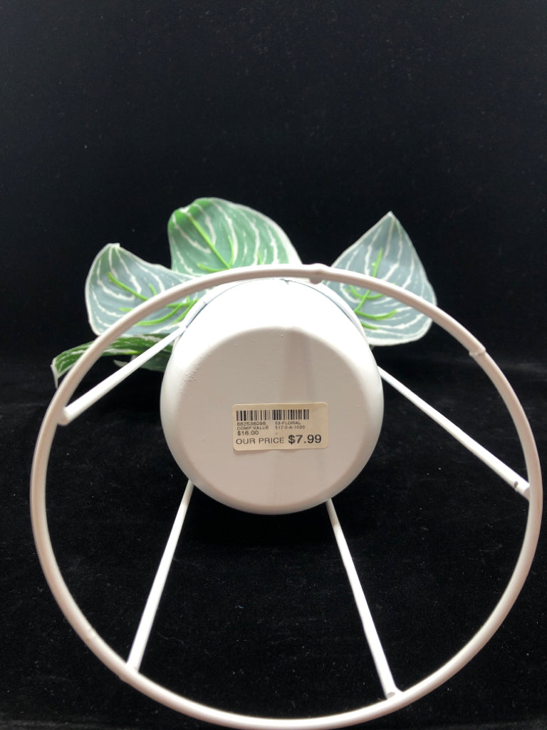 FAUX GREEN PLANT IN WHITE RAISED METAL PLANTER.