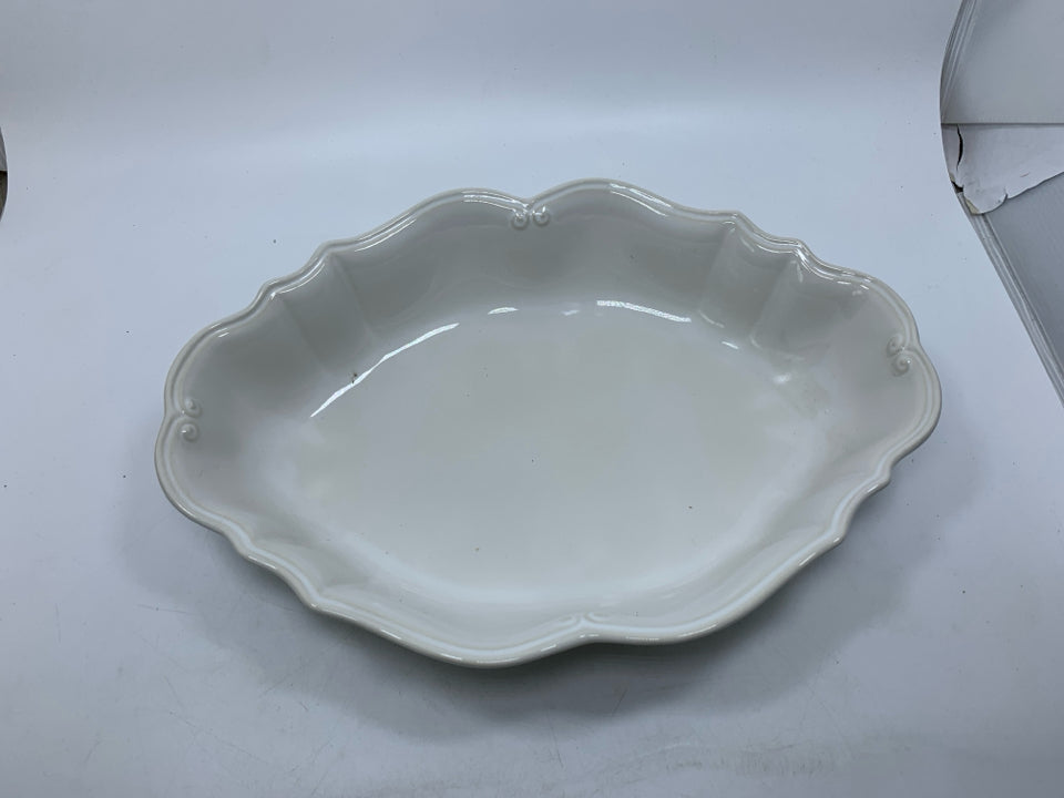 OFF WHITE OVAL STONEWARE SERVING BOWL W/ DETAILED EDGE.