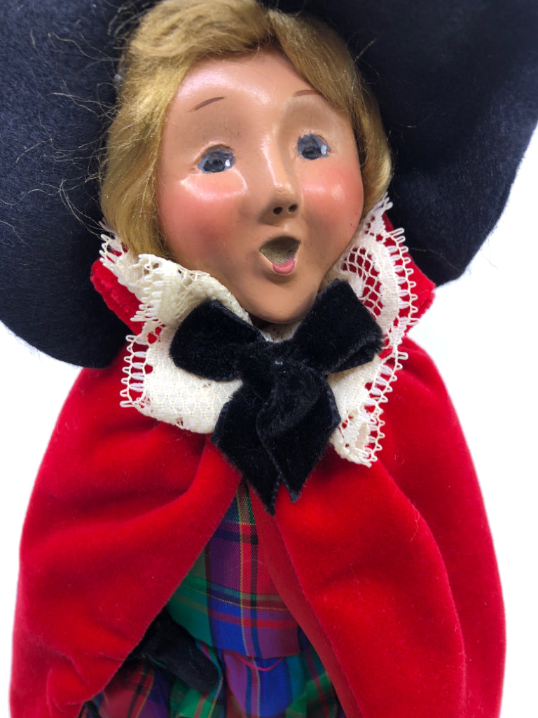 BYERS' CHOICE WOMAN IN RED COAT AND PLAID DRESS.
