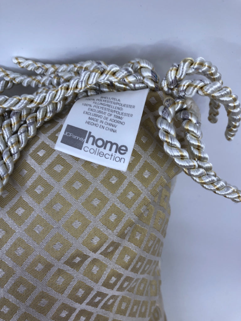 CREAM RECTANGLE AND GOLD PILLOW WITH TASSELS.