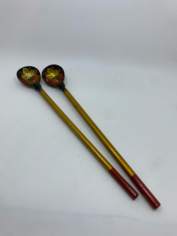 2 GOLD PAINTED LONG HANDLED WOODEN SPOONS.