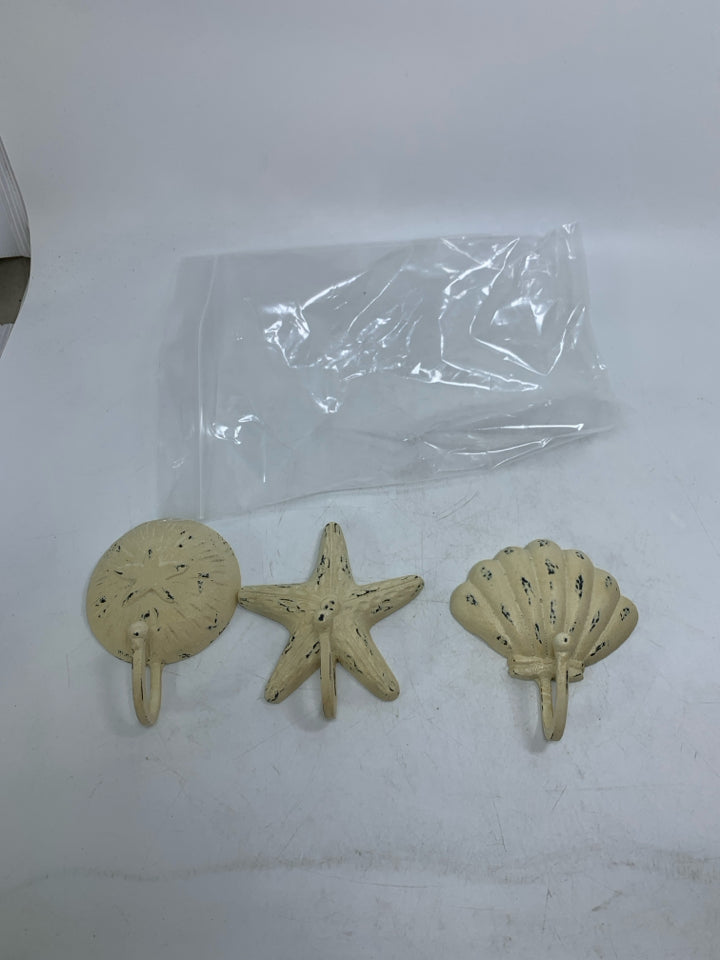 3 DISTRESSED CREAM METAL WALL HOOKS SEA THEMED IN BAG.