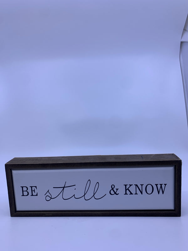 "BE STILL" BLACK LETTERS WHITE BACKGROUND WALL ART.