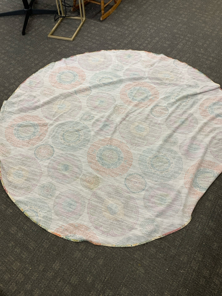 CREAM CIRCLE TABLECLOTH W/ COLORFUL MEDALLION PATTERN.