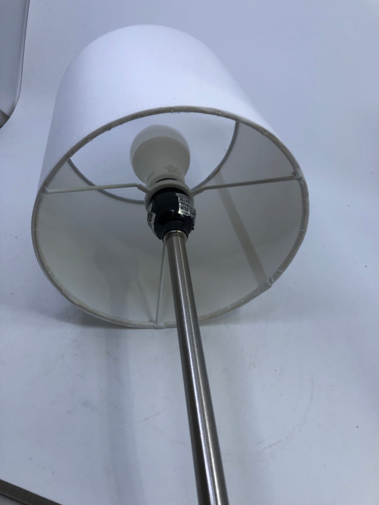 SKINNY SILVER METAL BASE LAMP W/ WHITE SHADE.
