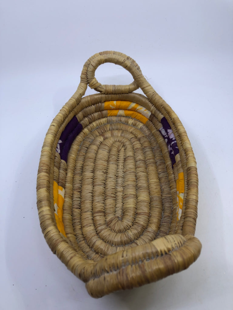 SWIRLED WICKER BASKET W/YELLOW AND PURPLE CLOTH & HANDLES.