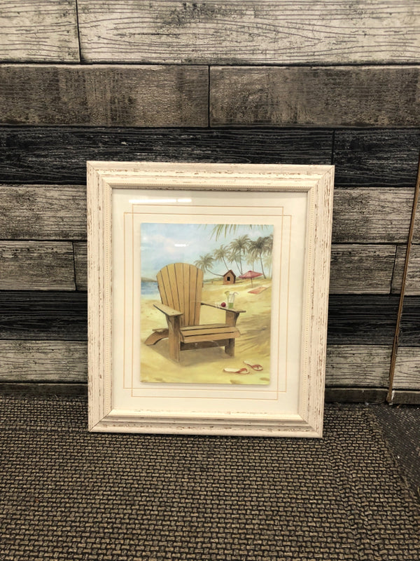 BEACH IN CHAIR IN WHITE DISTRESSED FRAME WALL HANGING.