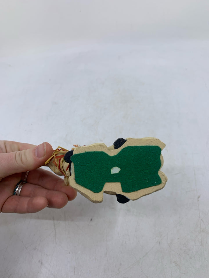 LAYING DOWN COW W/ STRAW AROUND NECK.