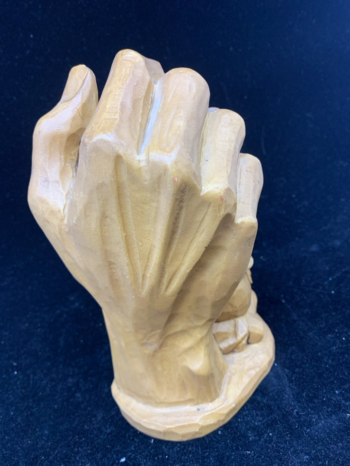 RESIN CARVED HAND HOLDING BABY.