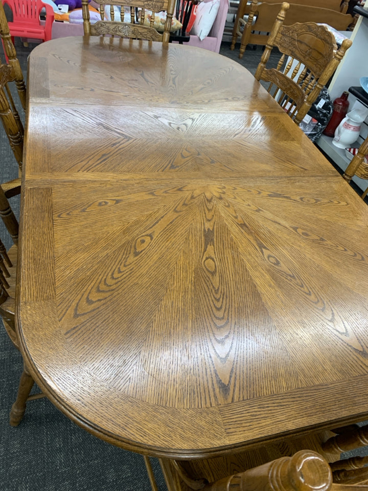 OVAL SOLID OAK DINING TABLE W/ 6 SPINDLE BACK CHAIRS.