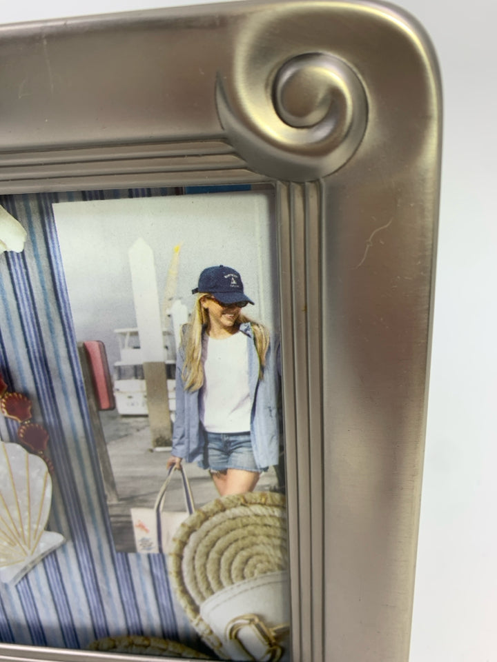 SILVER METAL PHOTO FRAME W/SWIRLED CORNERS.