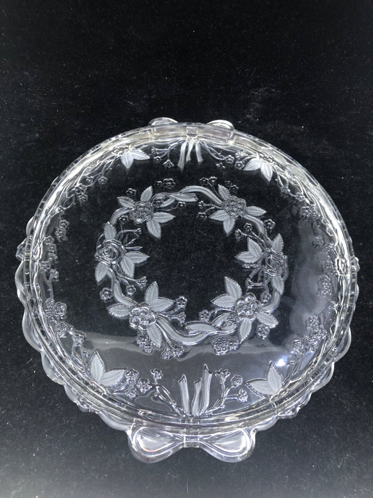 CLEAR GLASS CAKE PLATE W/ ETCHED FLOWERS/EMBOSSED BOW HANDLES.