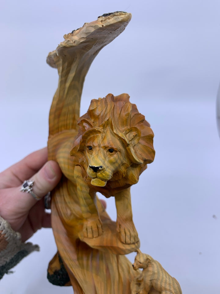 MALE LION ON ROCK COVERED BY TREE W/ LIONESS BELOW CARVED.