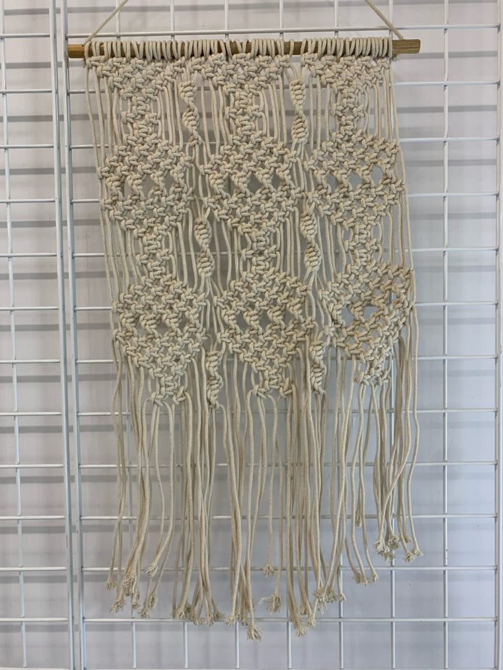 CREAM MACRAME WALL HANGING ON DOWEL ROD.