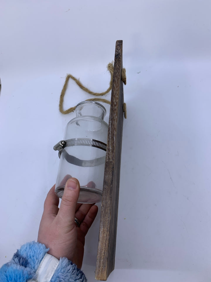 GLASS BOTTLE VASE ON PLANK.