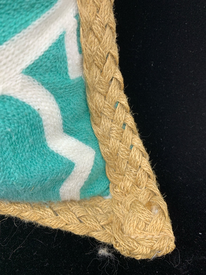 TEAL PILLOW W/WHITE DESIGN & BRAIDED BURLAP BORDER.