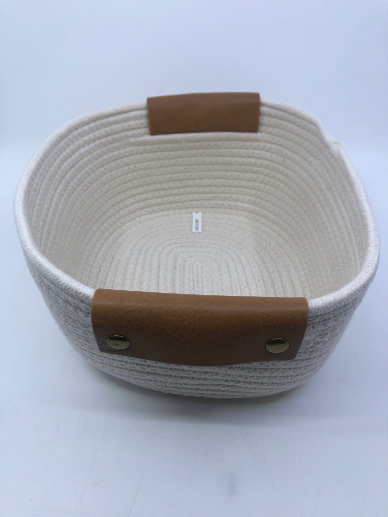 CREAM WOVEN FABRIC BASKET W FAUX LEATHER HANDLES.