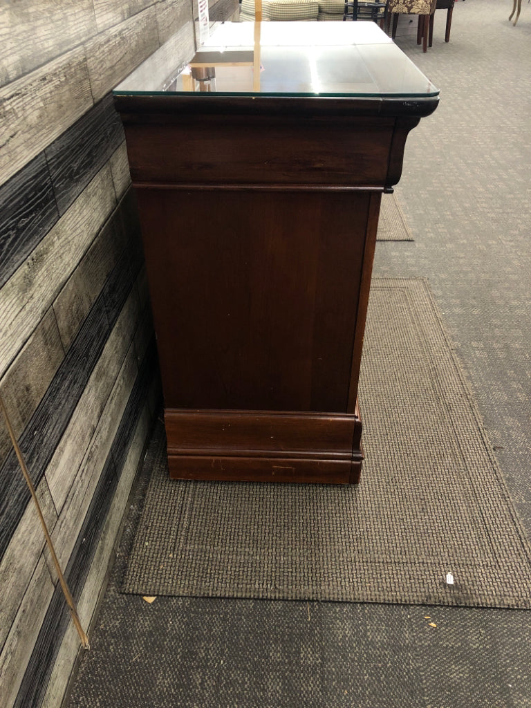 DARK CHERRY SIDE TABLE W/VTG METAL HANDLES & GLASS COVER ON WHEELS.