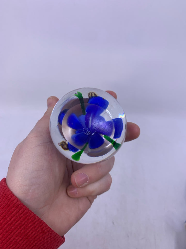 BLOWN GLASS SPHERE W/ BLUE FLOWER BEES FLYING ABOVE IT.