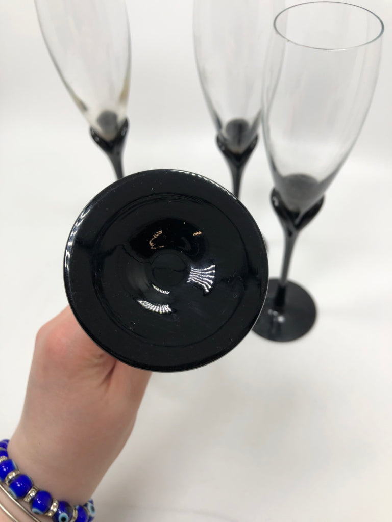 4 BLACK STEMMED CHAMPAGNE FLUTES.