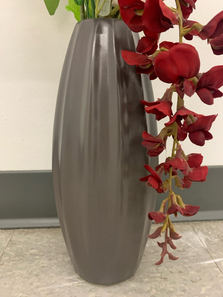 RED, WHITE AND BLUE FLOWERS IN TALL GRAY VASE.