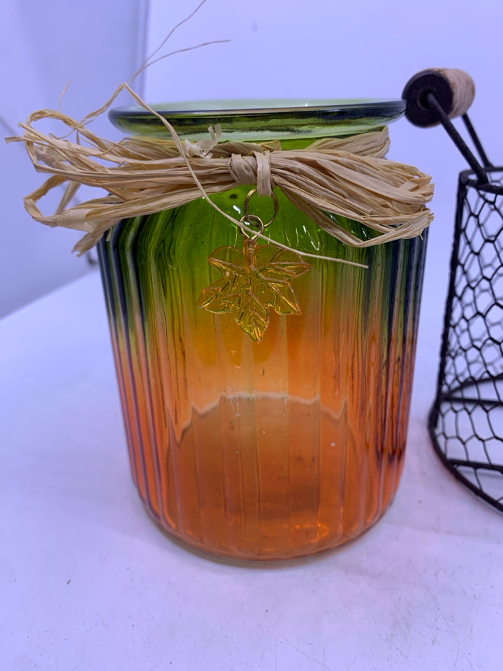 GLASS GREEN/ORANGE RIBBED JAR IN METAL CHICKEN WIRE INSERT CANDLE HOLDER.