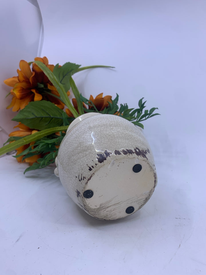 ORANGE FLORAL IN CREAM VASE.