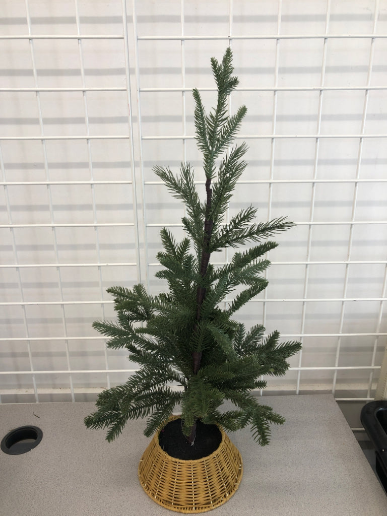 FAUX PINE TREE IN WICKER BASKET.