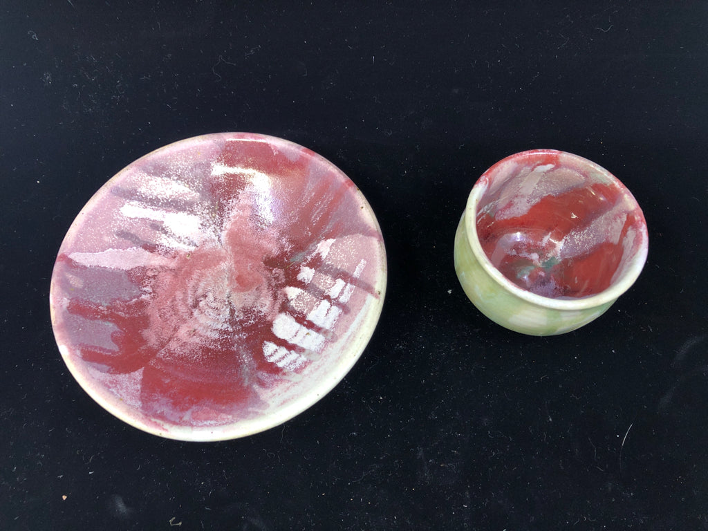 RED/PINK POTTERY CUP AND RAISED EDGE SAUCER.