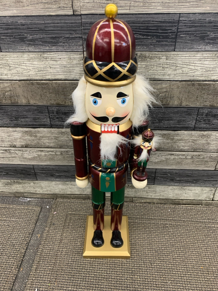 TALL NUTCRACKER HOLDING NUTCRACKER.